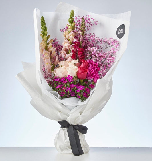 Wrapped Fig & Bloom bouquet with vivid pink, blush and burgundy flowers
