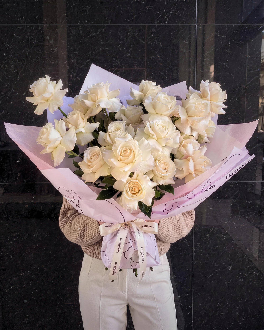 White reflexed roses by Fig & Bloom, bouquet held in pink wrap