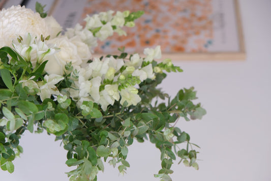 White flowers and eucalyptus in a bright room, Fig & Bloom studio still