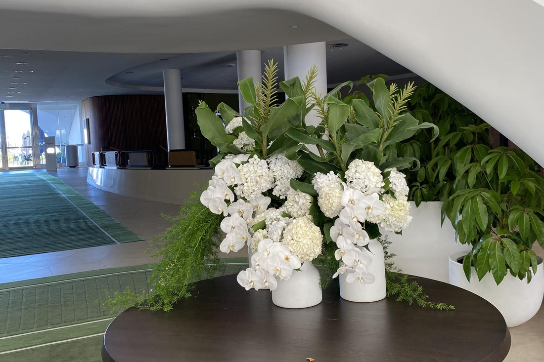 Composed white floral arrangement on a lobby table