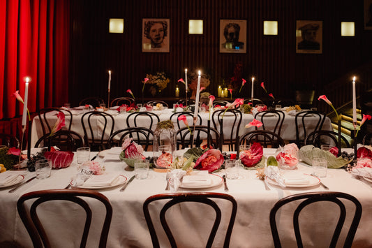 Long lunch table at Restaurant Hubert with low High Floral Design centrepieces, calla lilies and candles