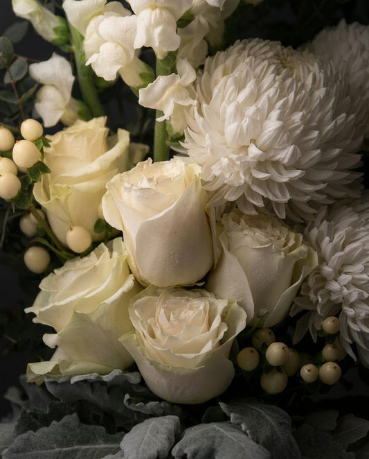 Close-up of the Lucerne bouquet: white roses, chrysanthemum, hypericum berries and dusty miller
