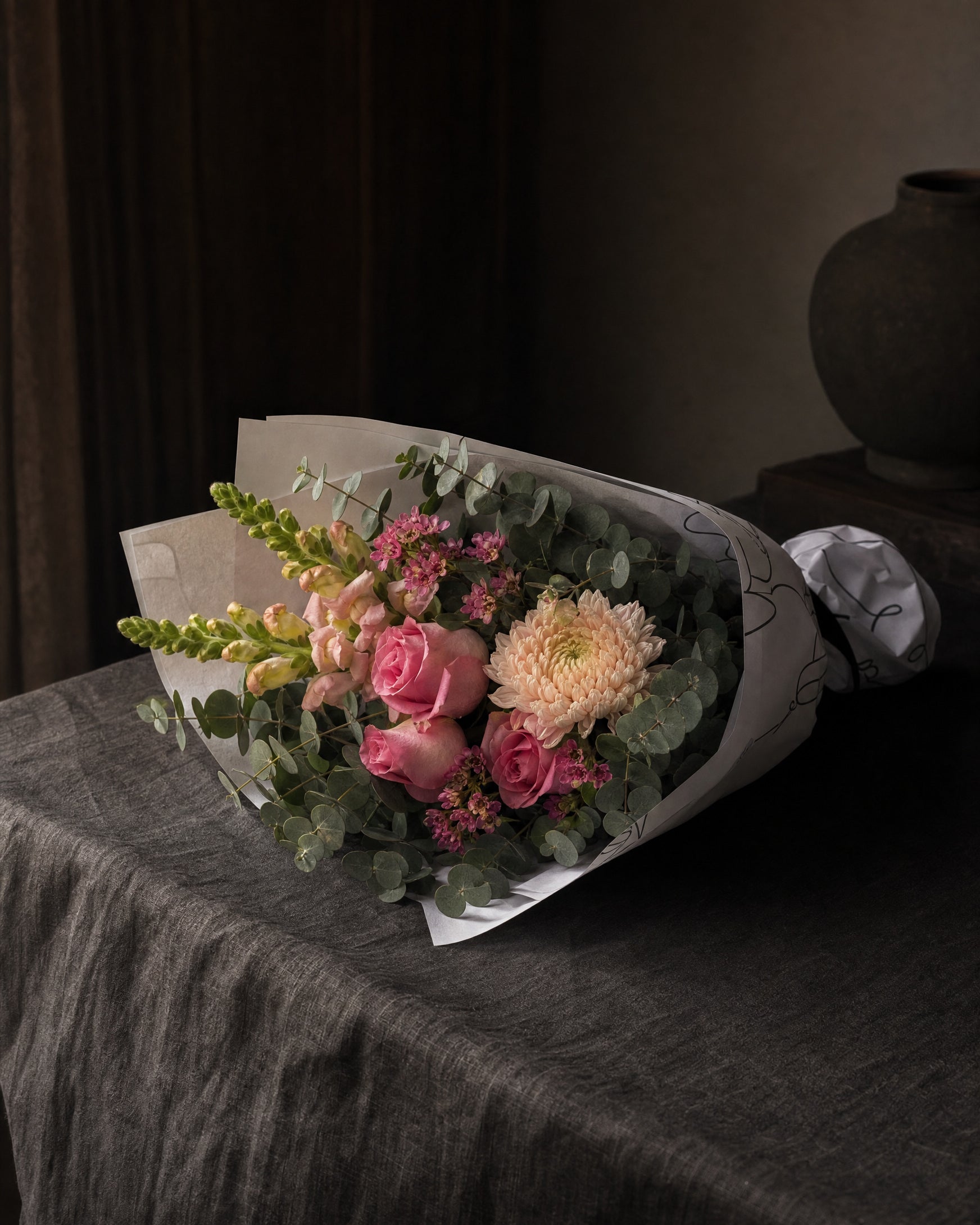 Positano Posy by Fig & Bloom lying on charcoal linen in window light