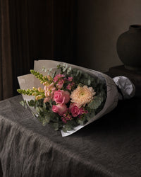 Positano Posy by Fig & Bloom lying on charcoal linen in window light