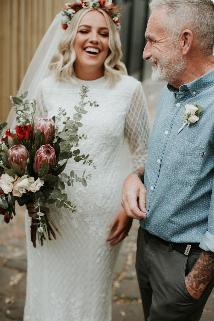 Bride and her father before the ceremony, carrying a protea and eucalyptus bouquet
