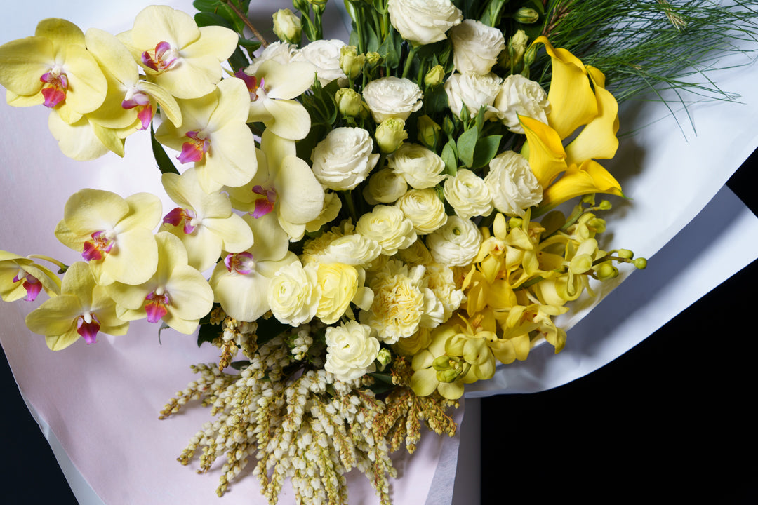 Close detail of the Soleil arrangement: yellow phalaenopsis, calla and cream carnation