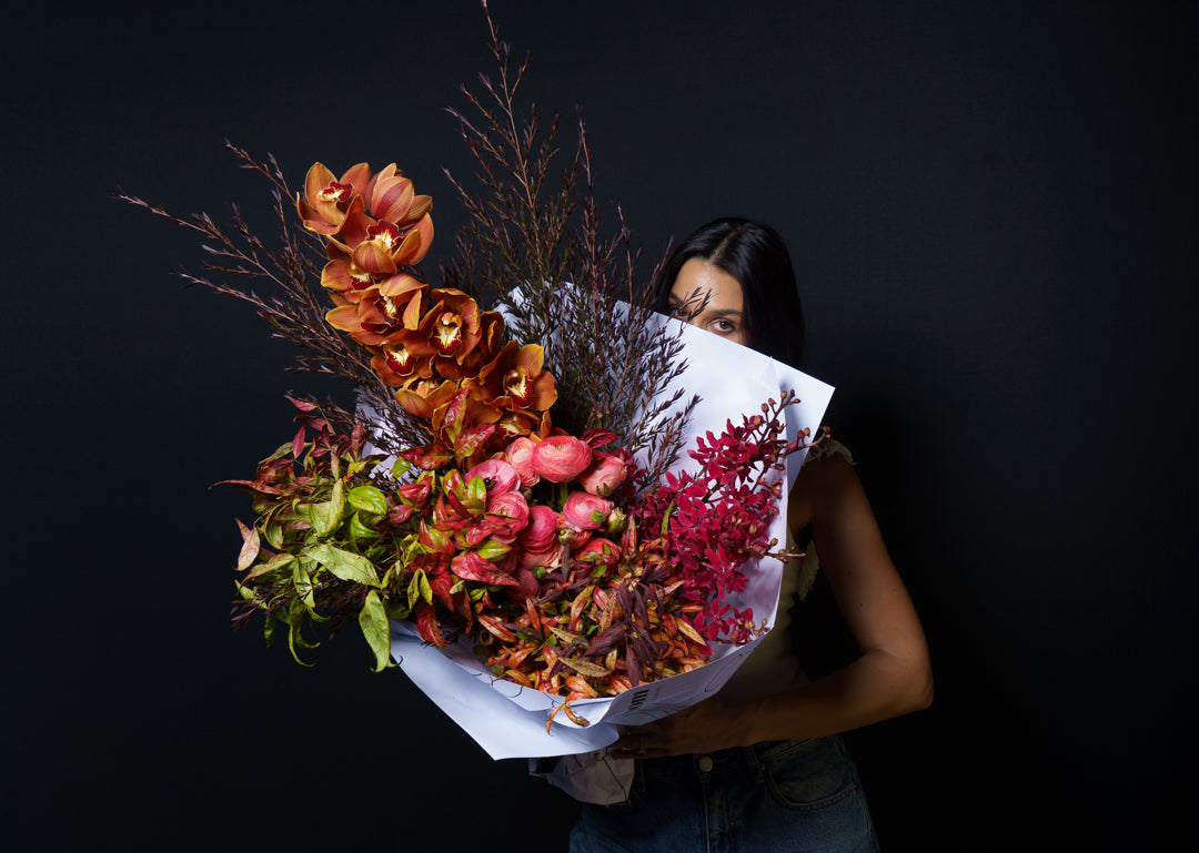 Model holding the Sienna arrangement against a black backdrop