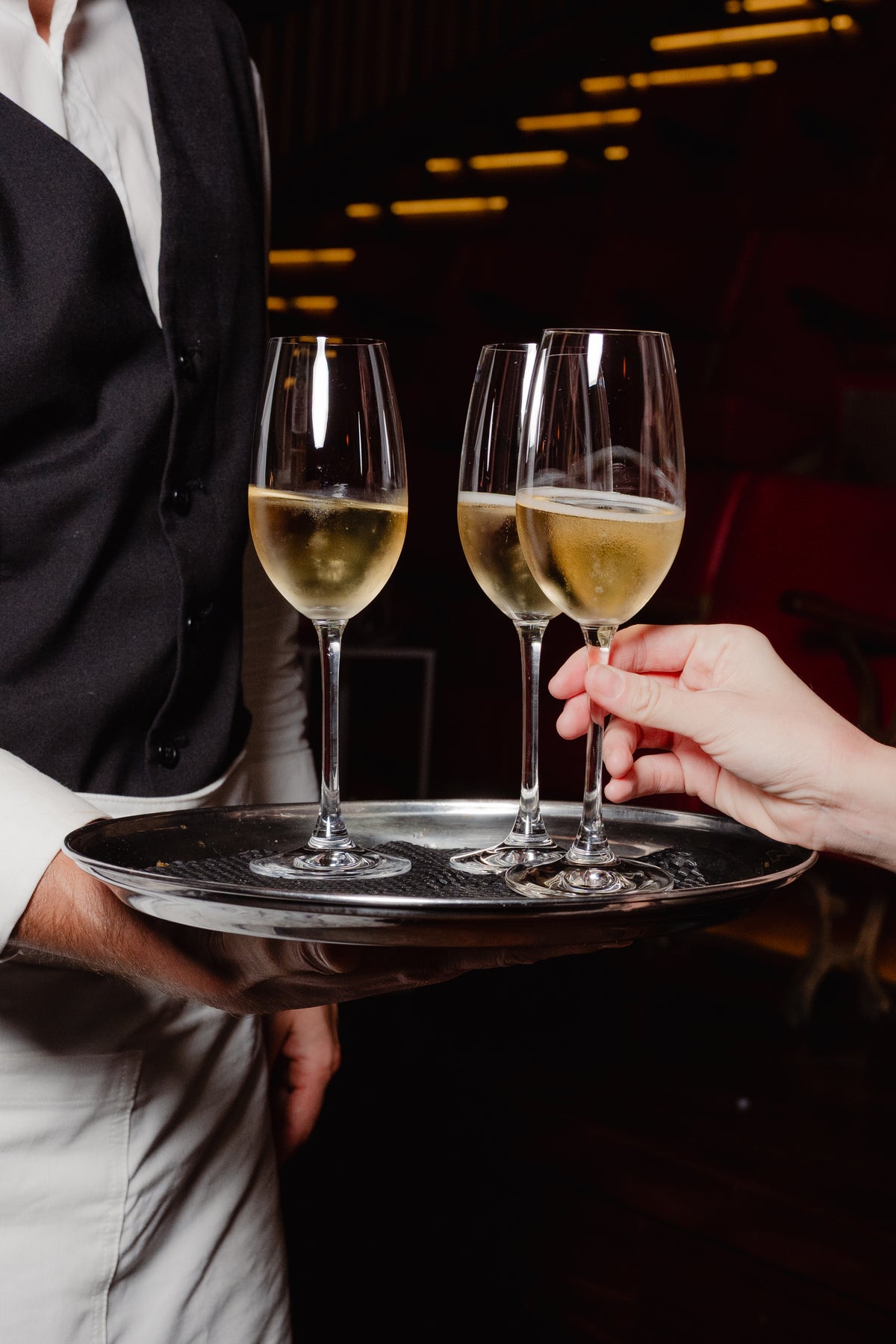 Glasses of sparkling wine offered on a silver tray