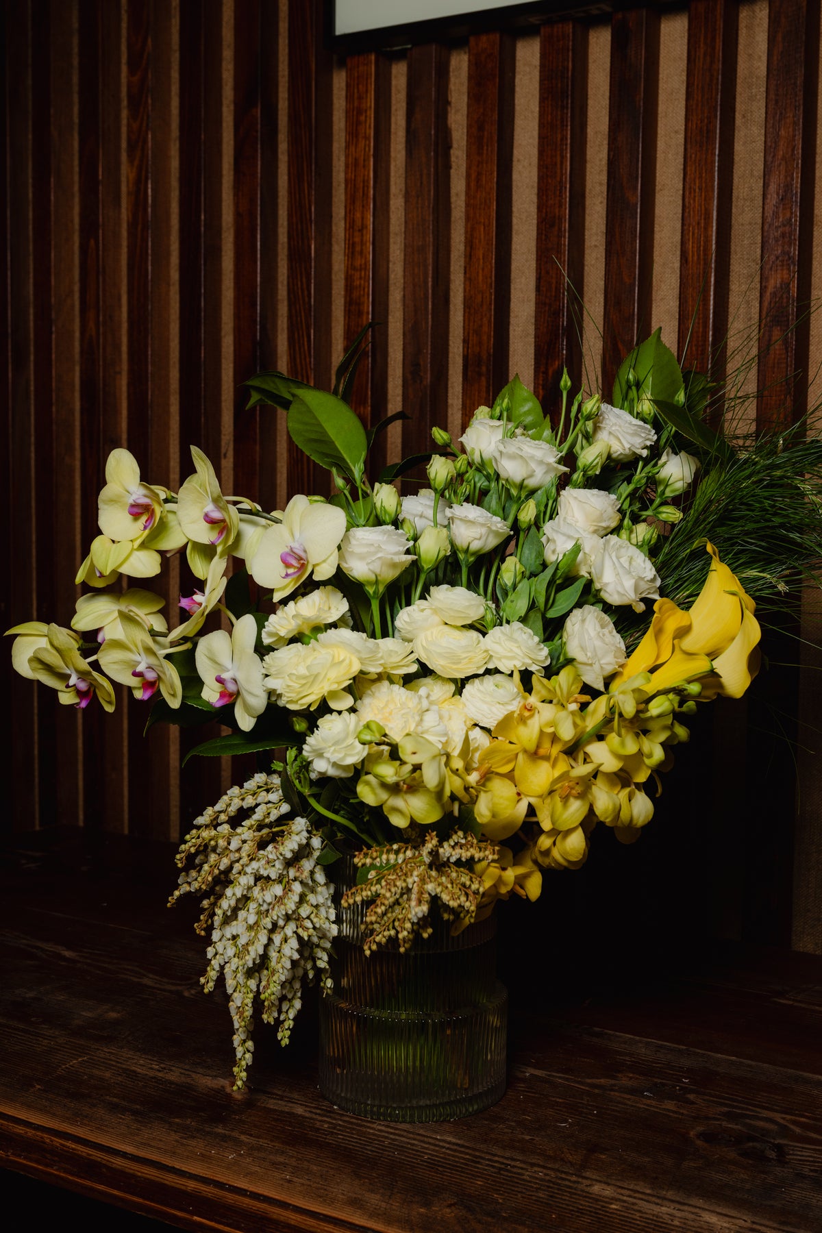 Soleil arrangement of yellow and white blooms on a timber stage