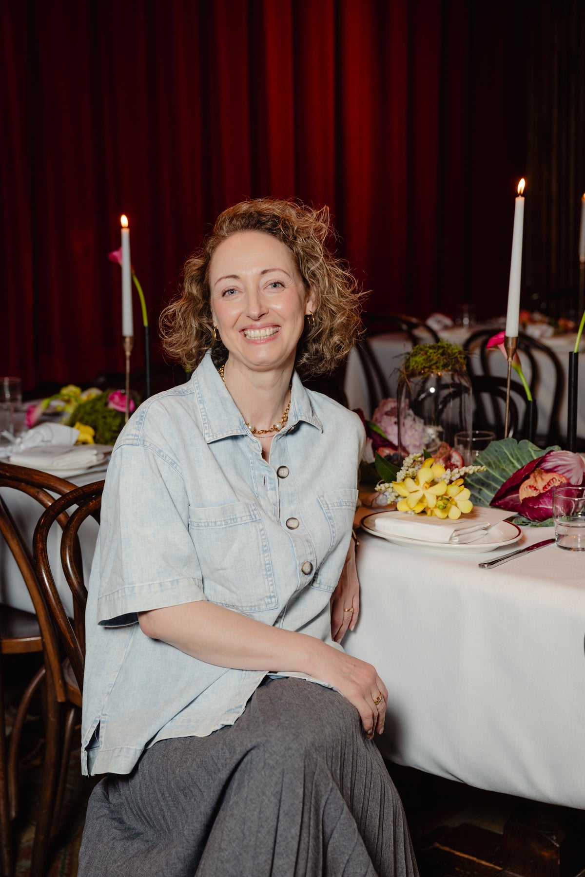 Kellie Brown, co-founder of Fig & Bloom, seated at the long lunch table
