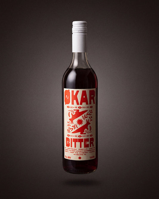 Okar Bitter Aperitivo 700mL by Applewood Distillery, on a warm charcoal studio sweep.