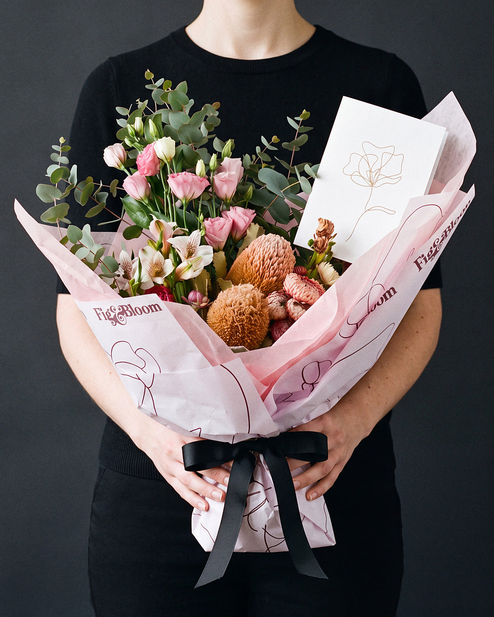 The Aperitif bouquet held at chest height with the Single Stem greeting card tucked into the wrap