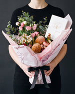 The Aperitif bouquet held at chest height with the Single Stem greeting card tucked into the wrap