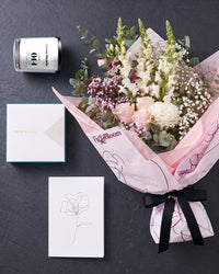 The Fuss photographed from above on charcoal slate: the Osaka Gesture bouquet, candle, Koko Black chocolates and greeting card.