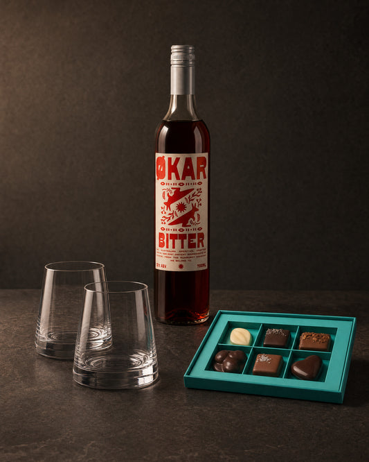 The Host gift bundle on charcoal: Stolzle Revolution tumblers, Okar Bitter aperitivo and Koko Black pralines