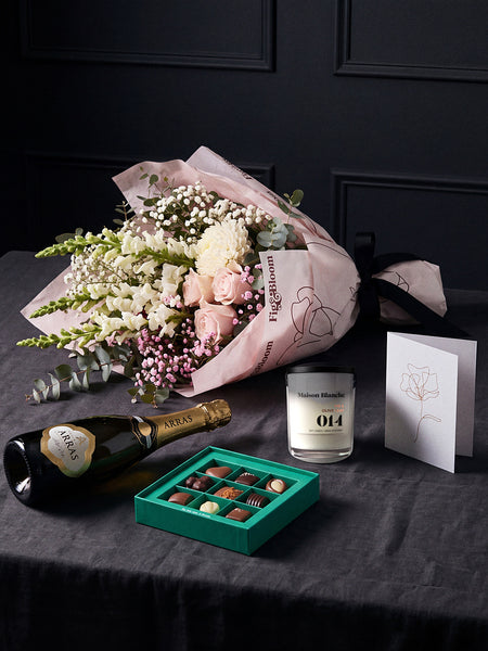 The Lot resting on charcoal linen in window light, with House of Arras, the Koko Black nine-piece selection, the candle and the greeting card alongside.