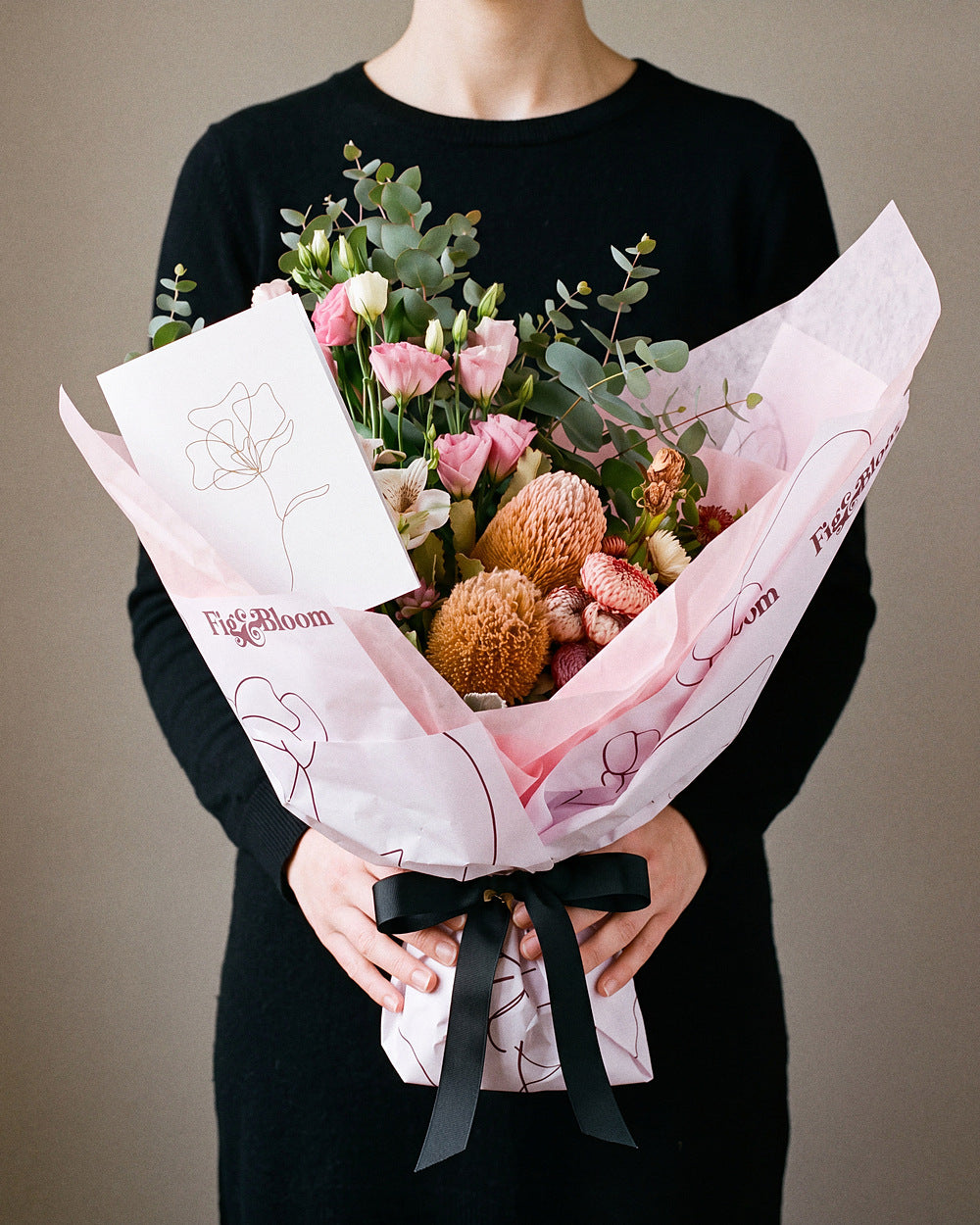 The Nightcap bouquet held at chest height with the Single Stem greeting card tucked into the wrap