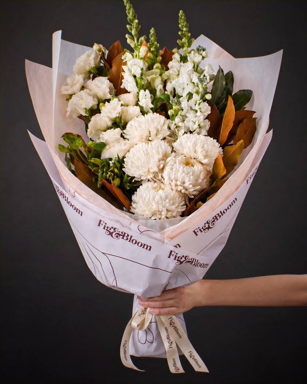The Toast, the Pyrenees bouquet held out by one hand against a charcoal backdrop.