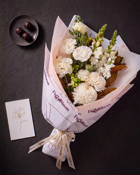 The Toast photographed from above on charcoal slate: the Pyrenees Gesture bouquet, dark chocolate marbles and the greeting card.