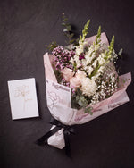 The Wish photographed from above on charcoal slate: the Osaka Gesture bouquet and the Single Stem greeting card.