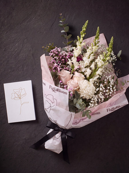 The Wish photographed from above on charcoal slate: the Osaka Gesture bouquet and the Single Stem greeting card.