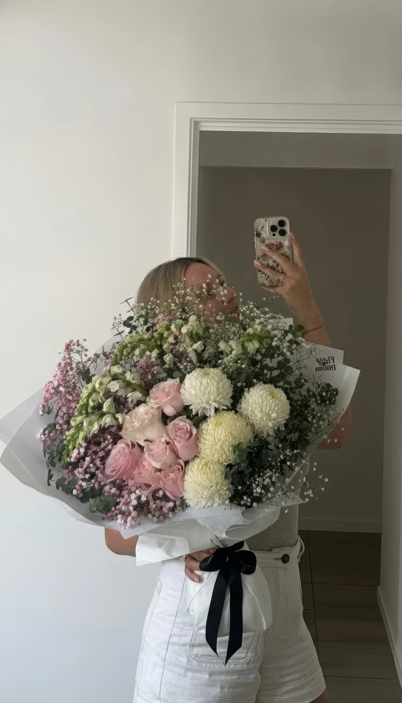 Mirror portrait with an oversized pastel Fig & Bloom bouquet