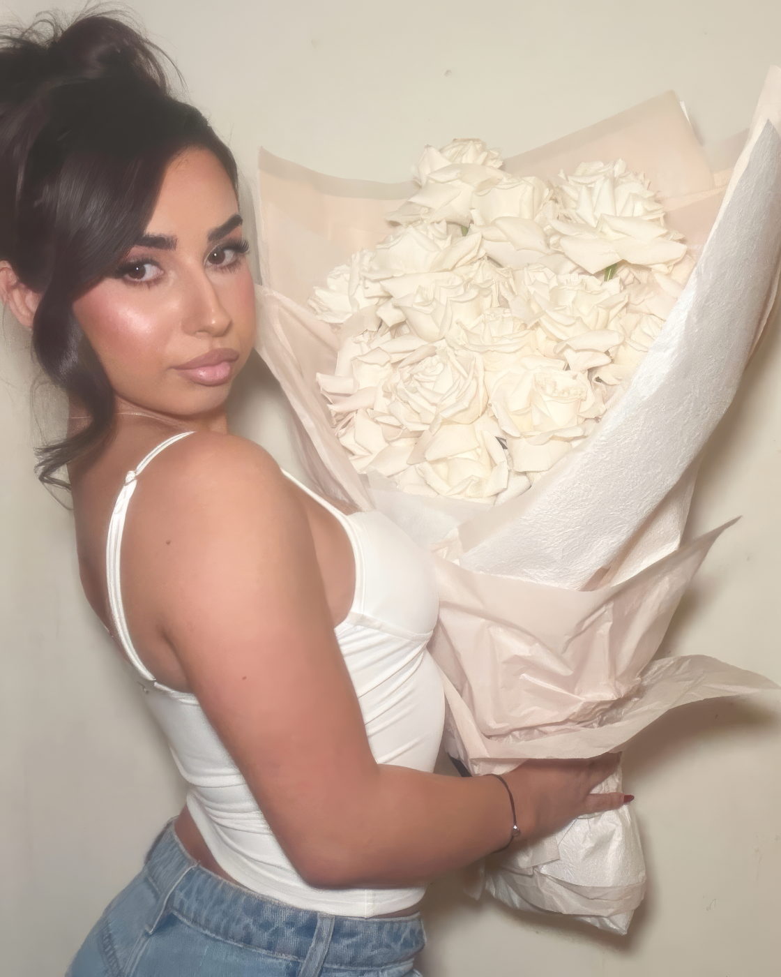 Woman posing with an oversized bouquet of white roses